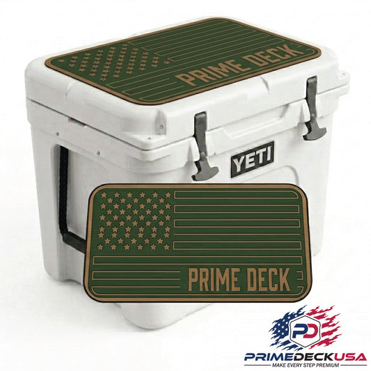 A white YETI cooler with dark green and tan 'PRIME DECK' mats on top, shown on a white background with a larger mat overlay and the Prime Deck USA logo in the bottom right corner.