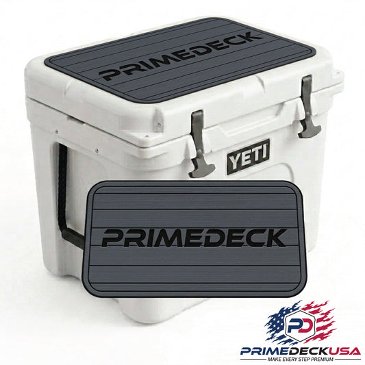 A white YETI cooler with black PRIMEDECK non-slip rubber mats on the lid and front, shown on a white background with a PrimeDeckUSA logo in the bottom right corner.