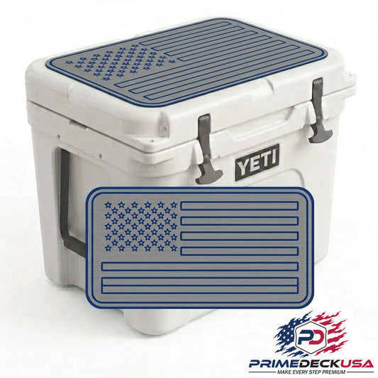 A white YETI cooler with a dark blue American flag patterned rubber mat on top and a matching front bumper mat, shown on a white background with a Prime Deck USA logo in the corner.